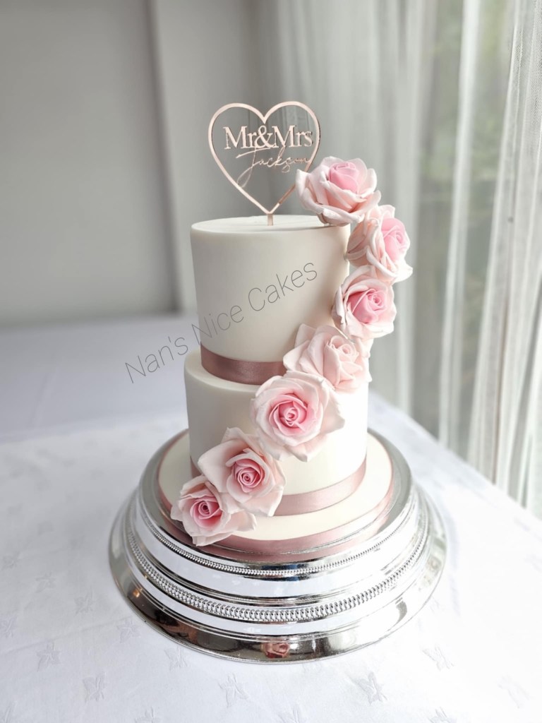 Simple, classic two tier wedding cake white with pink roses cascading down