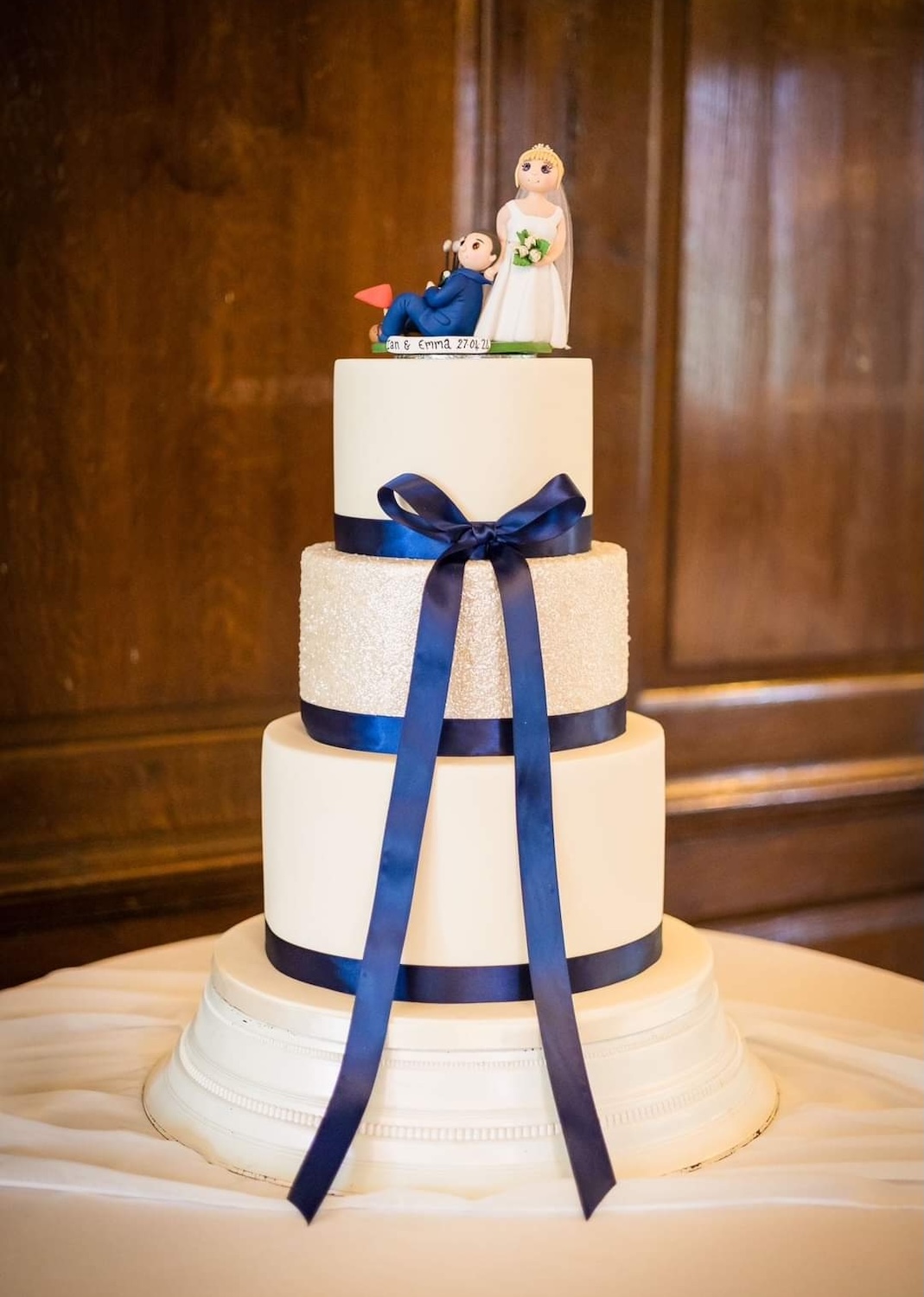 white tiered wedding cake - fondant bride and groom with navy ribbon