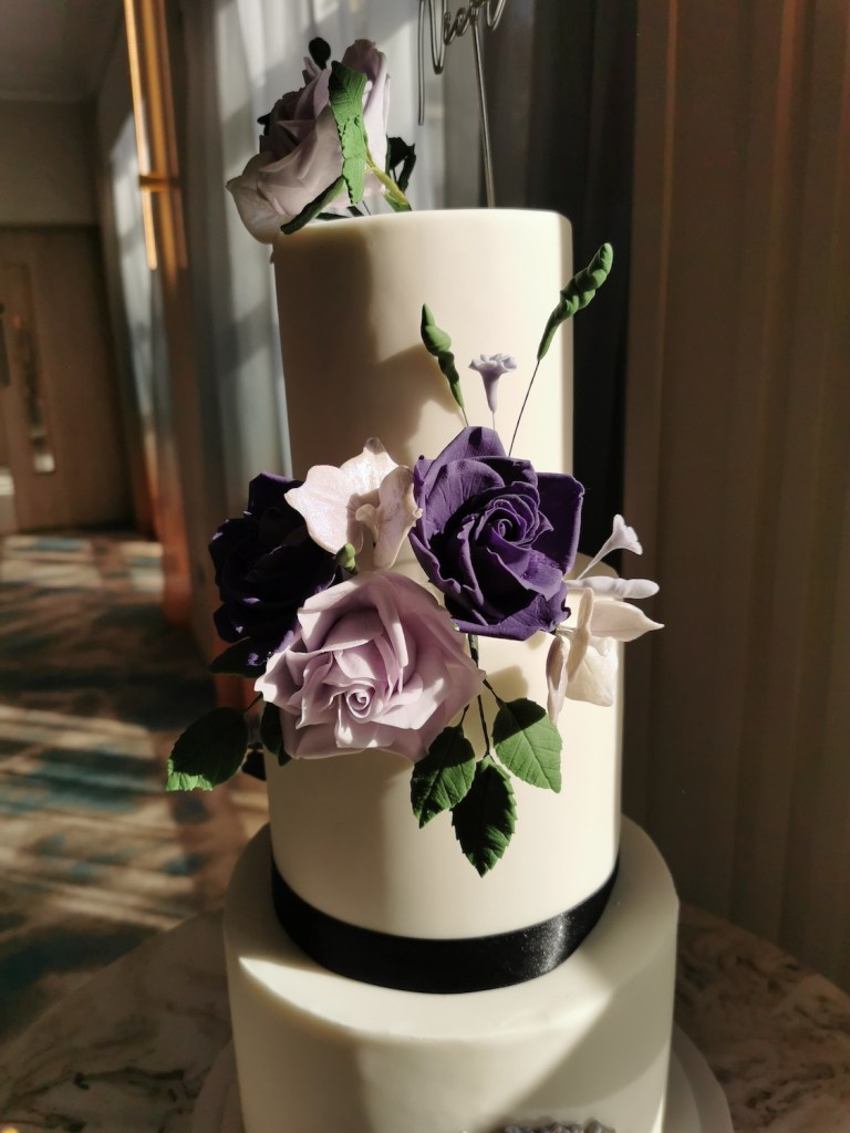 wedding cake with handmade purple roses