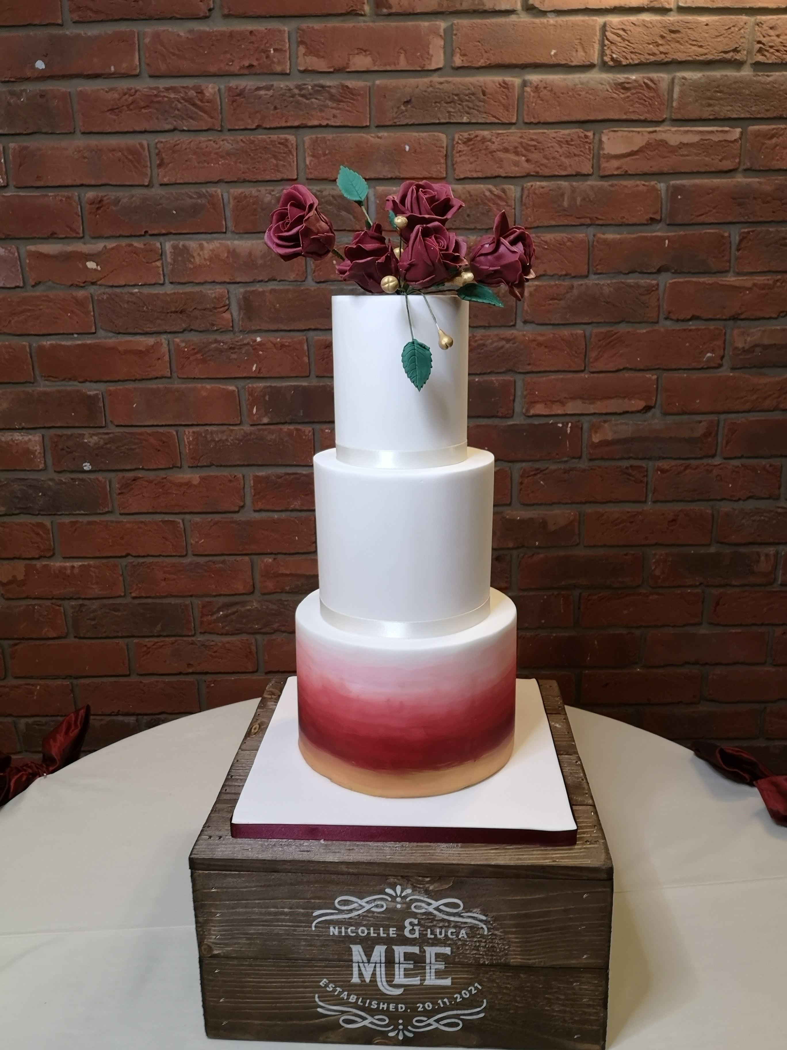 white and deep red ombre wedding cake with burgundy roses