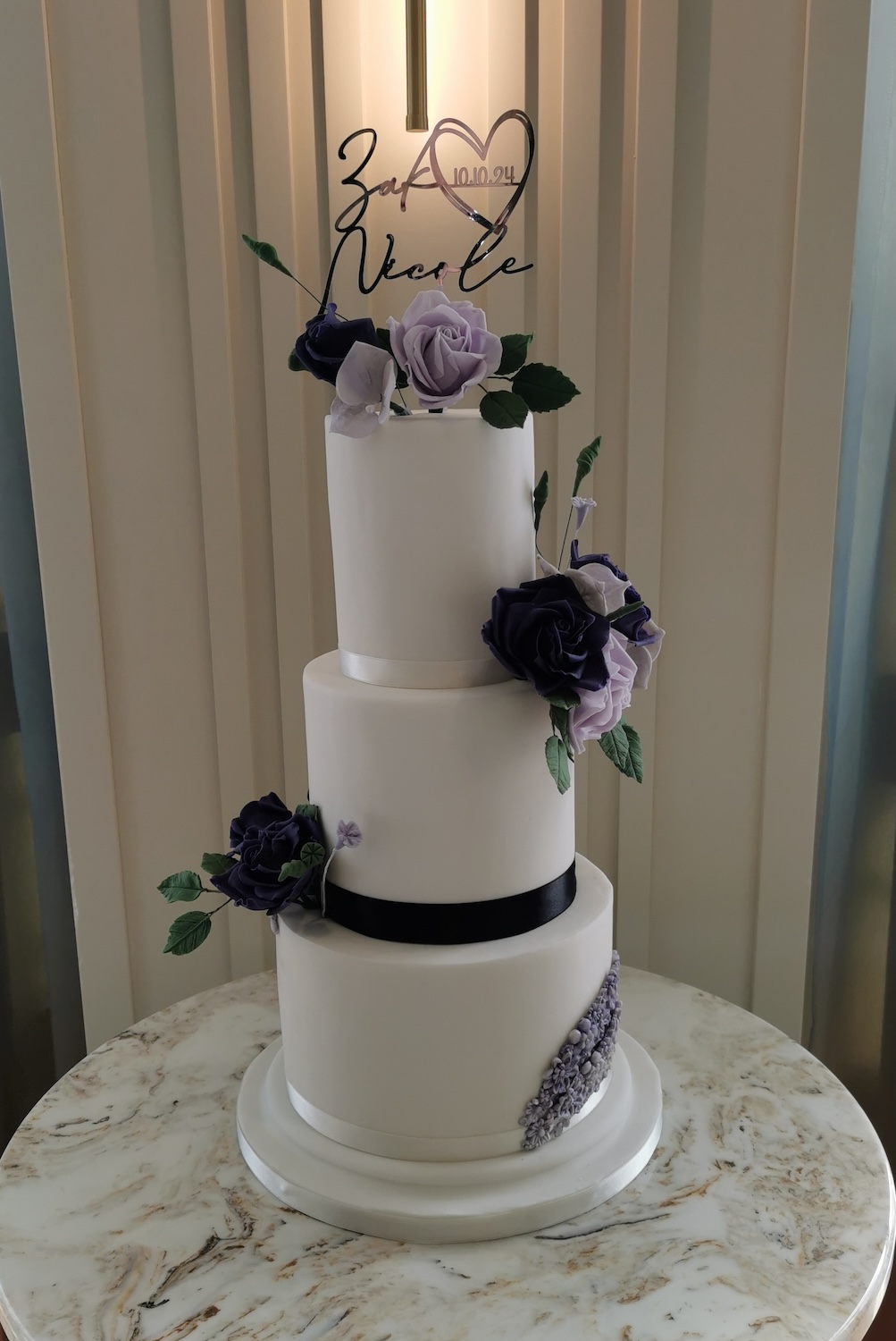 white wedding cake with purple roses